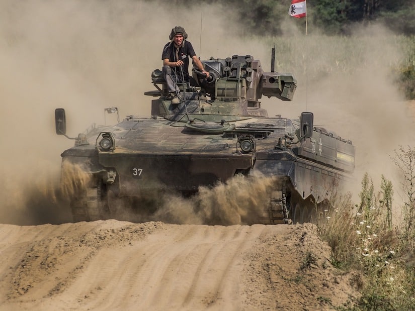 Panzer auf einem Weg, wo ein Mann aus der Kommandoluke schaut