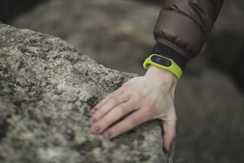 Arm mit Fitness-Armband lehnt auf einem Stein