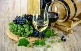 Ist Wein gesund? Ein Weinfass mit 2 Weingläsern und Trauben